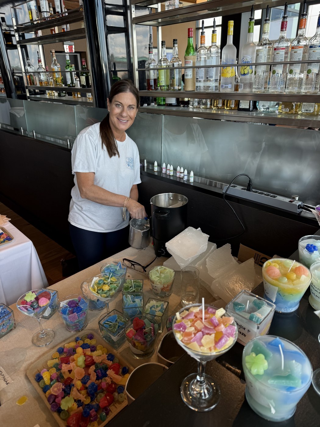 Samara smiling while working with colorful handmade candles