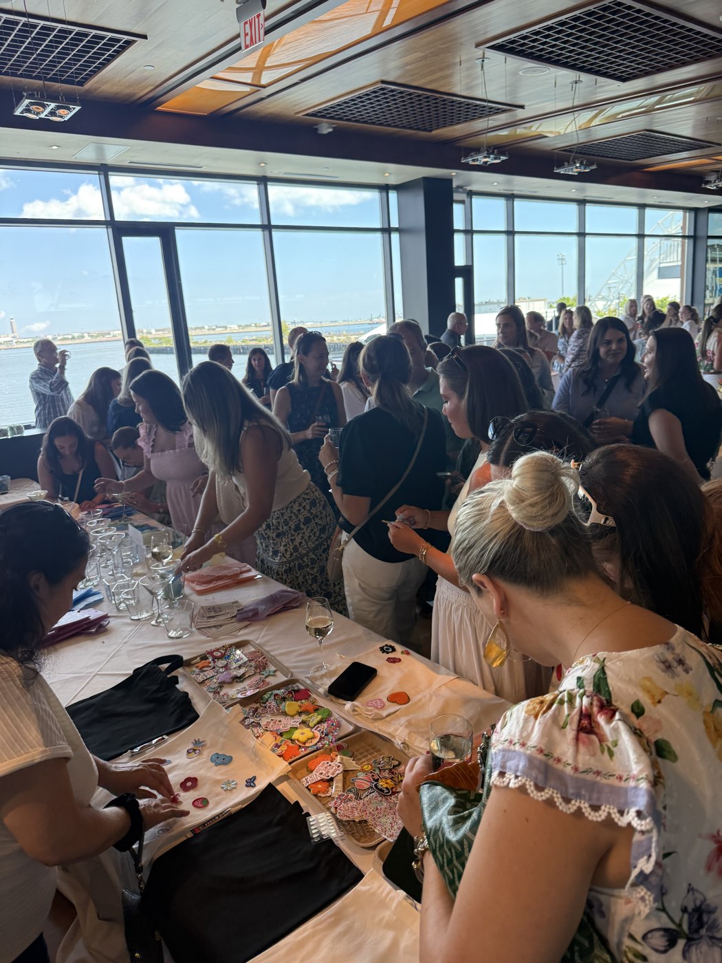 A large group painting pottery together at long tables