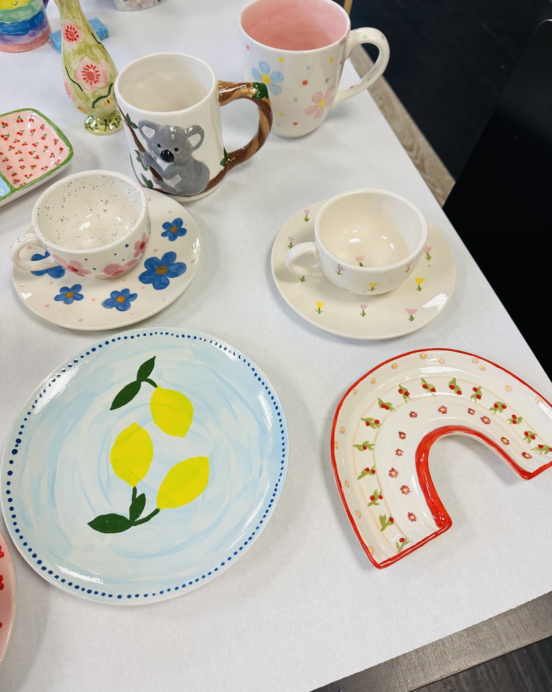 Colorfully painted mugs, bowls and plates