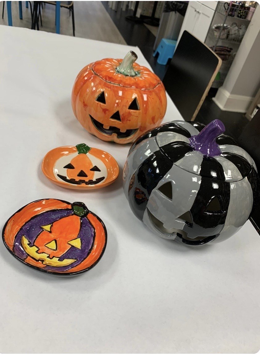 Orange jack-o-lantern, striped pumpkin and painted Halloween plates
