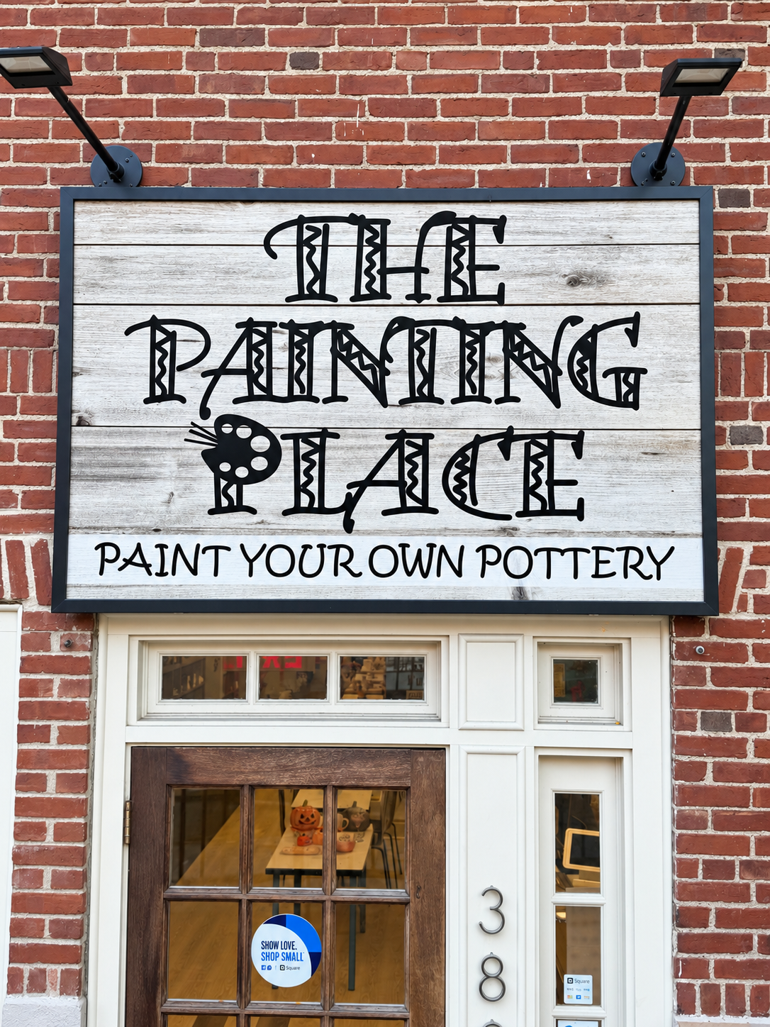 The Painting Place entrance with its wooden sign and brick exterior