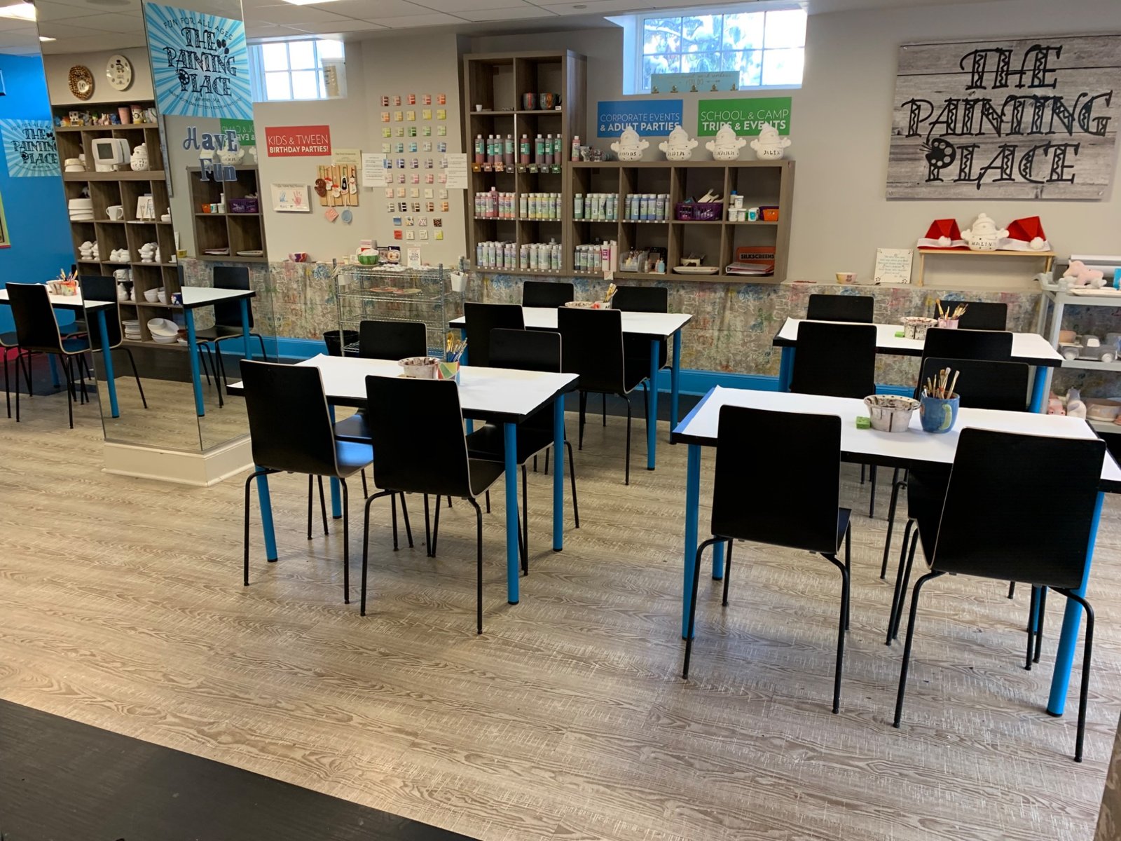 Bright painting tables and The Painting Place sign in our spacious Wellesley studio