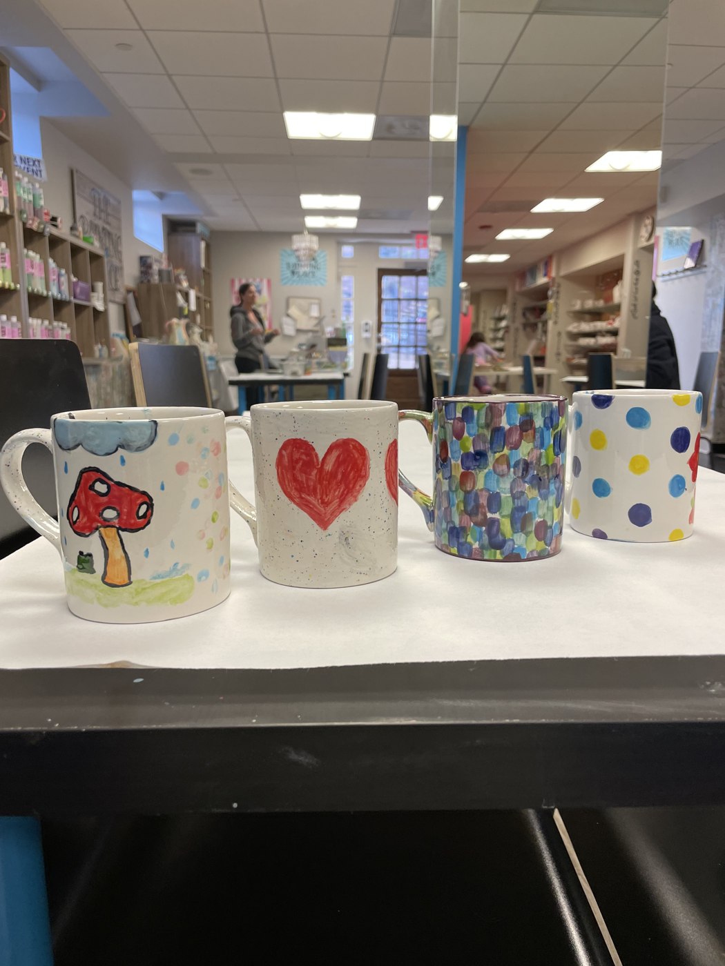 Hand-painted mugs displayed in The Painting Place studio